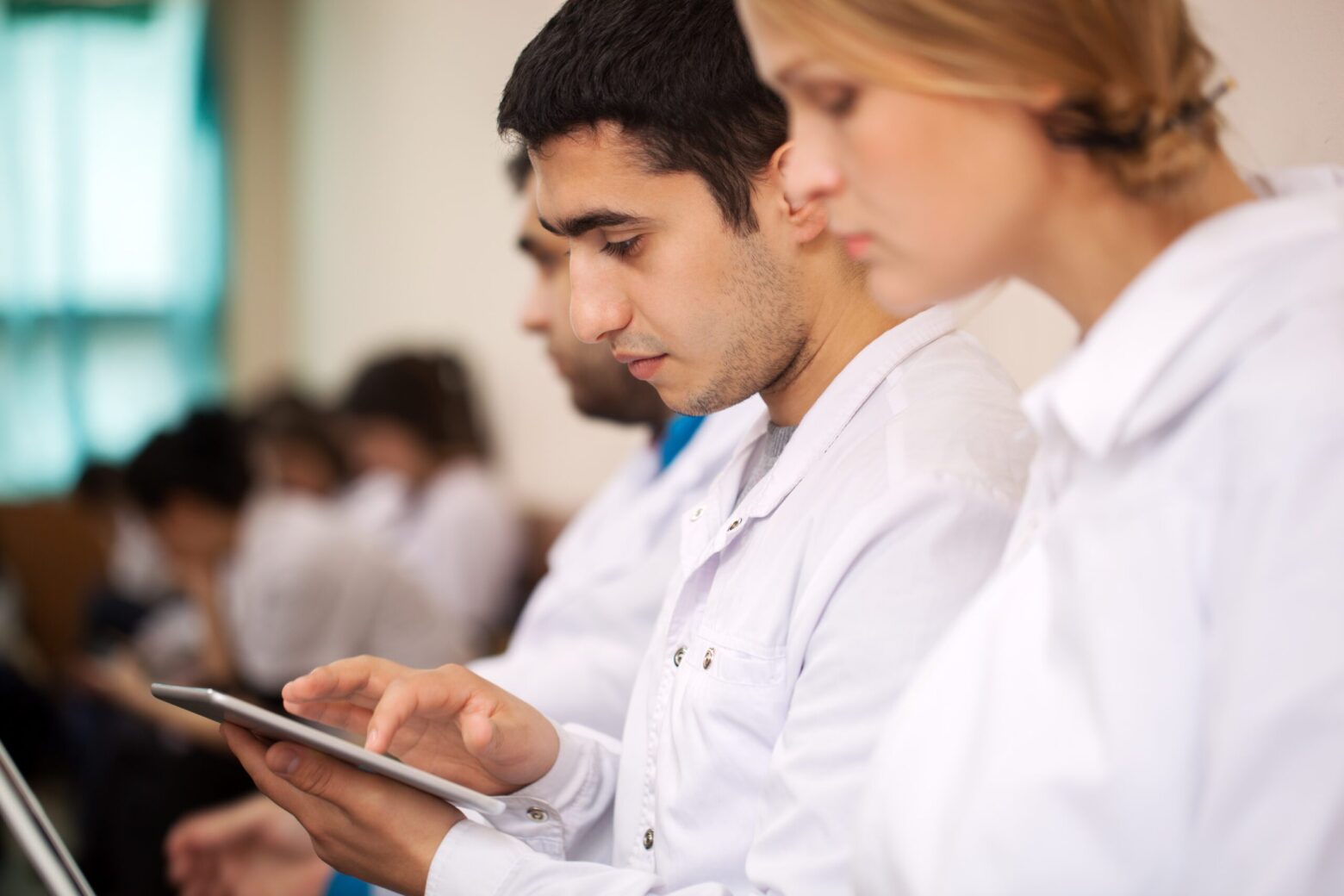 Imagem mostra estudantes consultando informações em dispositivo móvel